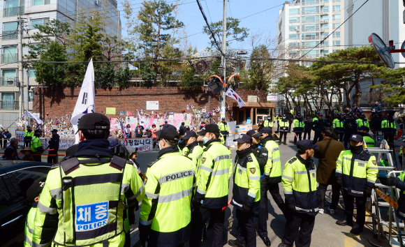 박근혜 전 대통령의 구속영장 실질심사를 하루 앞 둔 29일 서울 삼성동 박 전 대통령 자택 주변에서 경찰들이 취재진들을 향해 과격한 행동을 보이는  지지자를 저지하고 있다.  정연호 기자 tpgod@seoul.co.kr