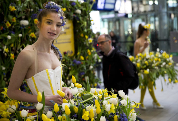 29일(현지시간) 꽃으로 만든 드레스를 입은 모델이 네덜란드 위트레흐트 중앙역에 나타나 오가는 사람들의 시선을 끌고 있다. 이 이벤트는 큐켄호프 꽃 축제 홍보를 위해 마련됐다. AP 연합뉴스