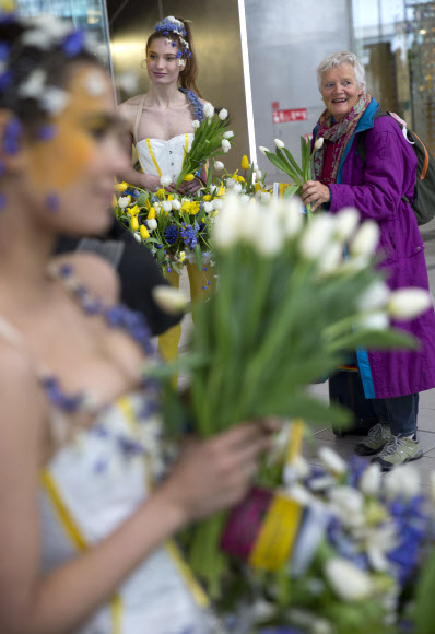 29일(현지시간) 꽃으로 만든 드레스를 입은 모델이 네덜란드 위트레흐트 중앙역에 나타나 오가는 사람들의 시선을 끌고 있다. 이 이벤트는 큐켄호프 꽃 축제 홍보를 위해 마련됐다. AP 연합뉴스