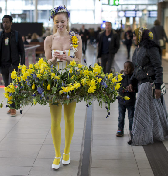 29일(현지시간) 꽃으로 만든 드레스를 입은 모델이 네덜란드 위트레흐트 중앙역에 나타나 오가는 사람들의 시선을 끌고 있다. 이 이벤트는 큐켄호프 꽃 축제 홍보를 위해 마련됐다. AP 연합뉴스