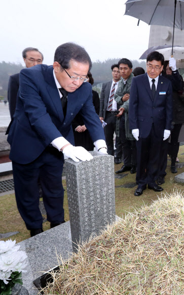 자유한국당 홍준표(왼쪽) 후보가 6일 광주 북구 운정동 국립5·18민주묘지를 방문해 한 민주 열사의 묘비를 어루만지며 참배하고 있다. 광주 연합뉴스