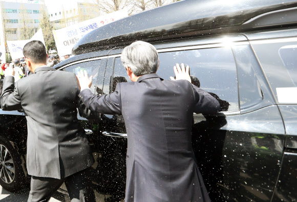 10일 오전 경남 창원시 의창구 경남도청 신관 대강당에서 열린 ’제35대ㆍ제36대 홍준표 도지사 퇴임식’을 마치고 청사를 떠나는 자유한국당 홍준표 대선후보의 차에 사회단체가 소금을 뿌리고 있다.  연합뉴스