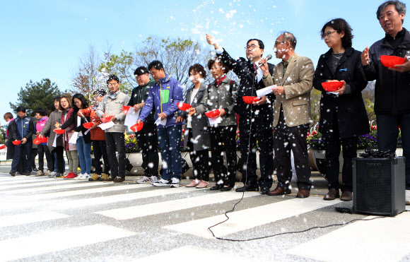 10일 오전 경남 창원시 의창구 경남도청 앞에서 ’적폐청산과 민주사회건설 경남운동본부’가 홍준표 자유한국당 대선후보의 정계은퇴를 요구하는 기자회견을 한 뒤 소금을 뿌리는 퍼포먼스를 하고 있다.  ㅍ