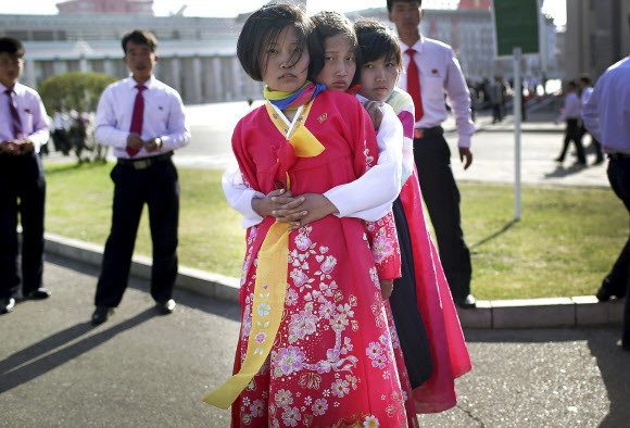 12일 북한 평양 김일성광장 앞에서 소녀들이 한복을 입고 태양절 기념행사 준비를 하고 있다.  AP 연합뉴스