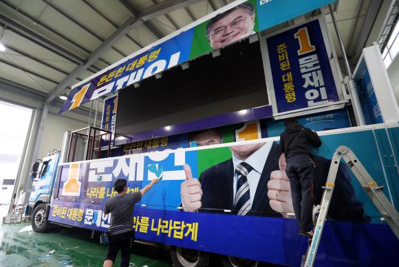 본격적인 대선 선거운동을 앞둔 14일 오후 경기도 김포시의 한 업체에 더불어민주당 문재인 대선후보의 유세 차량 래핑 작업이 한창이다.  연합뉴스