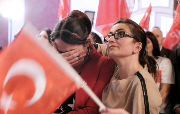 독일 베를린에 거주하는 터키인들이 16일(현지시간) 밤 터키 정부 형태를 의원내각제에서 ‘제왕적 대통령제’로 바꾸는 개헌안 국민투표에서 찬성 51.4%, 반대 48.6%로 개헌안이 통과되자 눈물을 흘리며 아쉬워 하고 있다. 베를린 AFP 연합뉴스