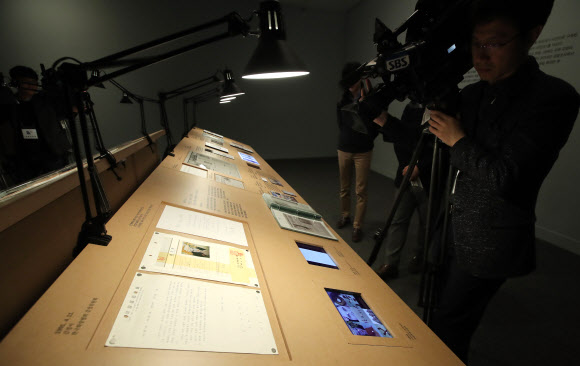 18일 오전 경기도 과천시 국립현대미술관에서 열린 고 천경자 화백 미인도 언론공개 행사에서 취재진이 미인도 위작논란 기사 등을 촬영하고 있다. 국립현대미술관은 이날 언론 공개를 시작으로 19일부터 과천관에서 열리는 ’소장품전: 균열’을 통해 미인도를 일반 공개한다.  미인도 위작 논란과 관련해 검찰은 지난해 12월 미인도가 진품이라고 발표했지만 유족측은 이에 맞서 항고한 상태다. 연합뉴스