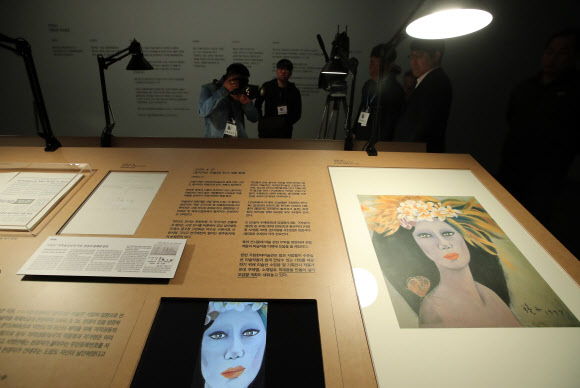 18일 오전 경기도 과천시 국립현대미술관에서 열린 고 천경자 화백 미인도 언론공개 행사에서 취재진이 미인도 위작논란 기사 등을 촬영하고 있다. 국립현대미술관은 이날 언론 공개를 시작으로 19일부터 과천관에서 열리는 ’소장품전: 균열’을 통해 미인도를 일반 공개한다.  미인도 위작 논란과 관련해 검찰은 지난해 12월 미인도가 진품이라고 발표했지만 유족측은 이에 맞서 항고한 상태다.  연합뉴스