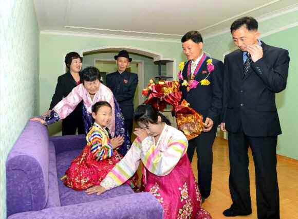 북한이 김일성 생일 105주년을 맞아 야심 차게 추진했던 대규모 건설 프로젝트 여명거리에서 아파트 입주가 시작됐다고 노동신문이 18일 보도했다. 신문은 김일성종합대학 교수?연구원들이 새 아파트에 제일 먼저 입주했다고 전했다. 사진은 새 아파트에 입주해 집안을 둘러보는 김일성대 교수와 가족들의 모습. 연합뉴스