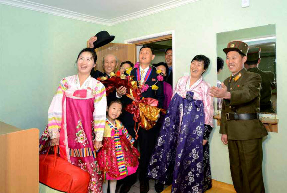 북한이 김일성 생일 105주년을 맞아 야심 차게 추진했던 대규모 건설 프로젝트 여명거리에서 아파트 입주가 시작됐다고 노동신문이 18일 보도했다. 신문은 김일성종합대학 교수?연구원들이 새 아파트에 제일 먼저 입주했다고 전했다. 사진은 새 아파트에 입주해 집안을 둘러보는 김일성대 교수와 가족들의 모습. 연합뉴스