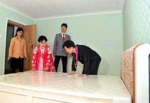 북한이 김일성 생일 105주년을 맞아 야심 차게 추진했던 대규모 건설 프로젝트 여명거리에서 아파트 입주가 시작됐다고 노동신문이 18일 보도했다. 신문은 김일성종합대학 교수?연구원들이 새 아파트에 제일 먼저 입주했다고 전했다. 사진은 새 아파트에 입주해 집안을 둘러보는 김일성대 교수와 가족들의 모습. 연합뉴스