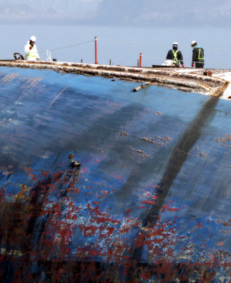 18일 오전 목포신항에 거치된 세월호 우현 위에서 관계자들이 전날 기상악화로 중단된 안전구조물 설치작업을 하고 있다. 이날 오전에 세월호현장수습본부는 선체 수색 및 미수습자 수습 계획을 발표할 예정이다.  연합뉴스