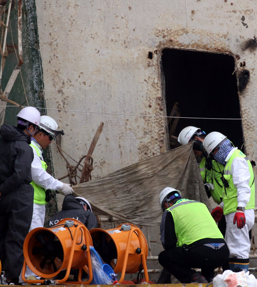 18일 오후 목포신항에 거치된 세월호 좌현 부분에서 관계자들이 수색을 한 뒤 모포로 보이는 유류품들을 정리하고 있다.  연합뉴스