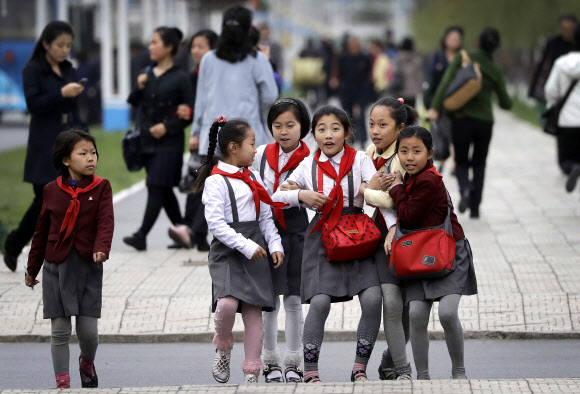 북한의 여학생들이 19일(현지시간) 평양 미래과학자거리를 걷다 자신들의 사진이 찍히는 것을 알고 깜짝 놀라고 있다. AP 연합뉴스