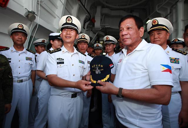 로드리고 두테르테 필리핀 대통령이 지난 1일 필리핀에 정박한 중국 군함에 승선해 중국 해군 모자를 건네받고 있다. 신화통신 홈페이지 캡처