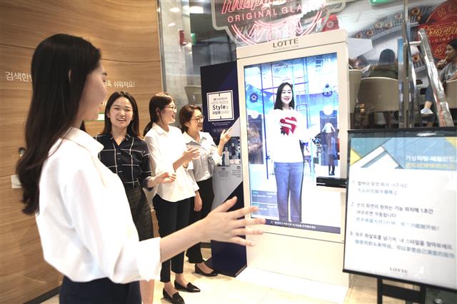 서울 중구 소공동 롯데백화점 본점에서 고객들이 디지털 거울을 활용한 ‘3D 가상 피팅 서비스’를 체험해 보고 있다. 롯데백화점 제공