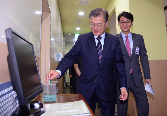 문재인 대통령이 12일 청와대 위민2관 직원식당에서 직원들과 오찬을 위해 식권을 내고 있다.  안주영 기자 jya@seoul.co.kr