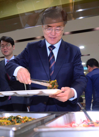 문재인 대통령이 12일 청와대 위민2관 직원식당에서 직원들과 오찬을 위해 식판에 음식을 담고 있다.  안주영 기자 jya@seoul.co.kr
