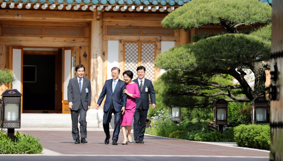 문재인 대통령(왼쪽 두 번째)이 15일 거처를 청와대로 옮긴 이후 처음으로 여민관 집무실에 출근하기 위해 부인 김정숙 여사(오른쪽 두 번째)의 배웅을 받으며 주영훈 경호실장(왼쪽 첫 번째), 송인배 전 더불어민주당 일정총괄팀장(오른쪽 첫 번째) 등과 함께 관저에서 나오고 있다. 2017. 05. 15 안주영 기자 jya@seoul.co.kr