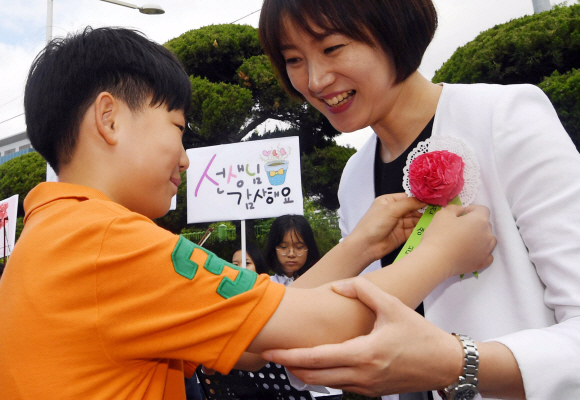 스승의 날인 15일 서울 송파구 풍성초등학교에서 학생들이 출근하는 선생님들에게 카네이션을 달아 주고 있다. 2017. 5. 15. 박윤슬 기자 seul@seoul.co.kr