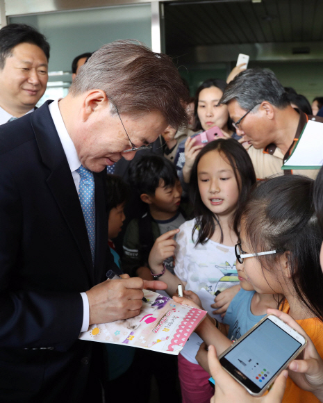 문재인 대통령이 15일 오후 서울 양천구 은정초등학교에서 열린 ’미세먼지 바로 알기 교실’ 행사를 마친 뒤 학교를 떠날 때 학생들에게 사인해 주고 있다. 2017. 05. 15 안주영 기자 jya@seoul.co.kr