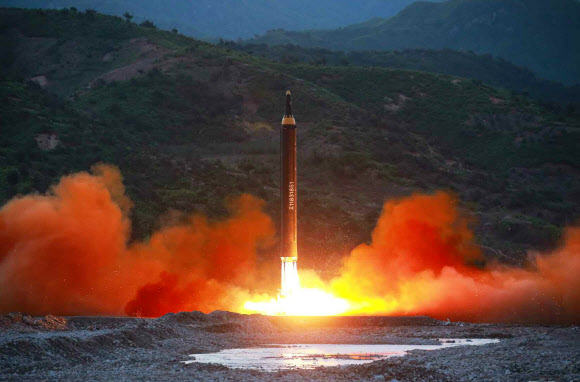북한 노동신문이 15일 공개한 사진 속에서 전날 시험 발사에 성공한 것으로 알려진 신형 지대지 중장거리 미사일 ‘화성12형’이 화염을 뿜으며 솟구치고 있다. 연합뉴스