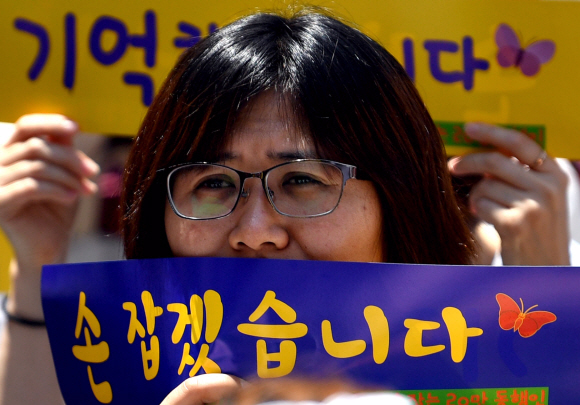 눈물을 글썽이는 수요집회 참가자