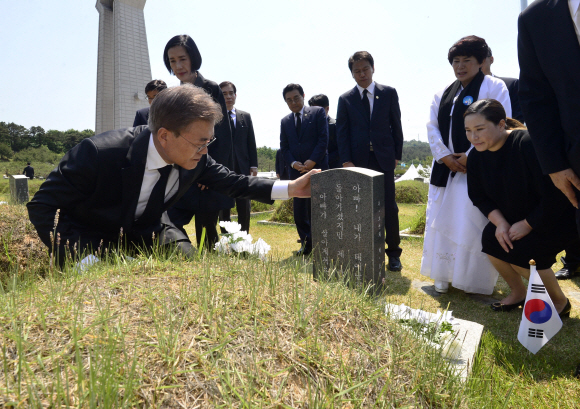 5.18 민주화 운동 37주년 기념식이 18일  광주 북구 운정동 국립 5.18 민주묘지에서 엄수된 가운데 문재인 대통령이 김재평의 묘에서 유가족과 이야기를 나누고 있다. 청와대사진기자단