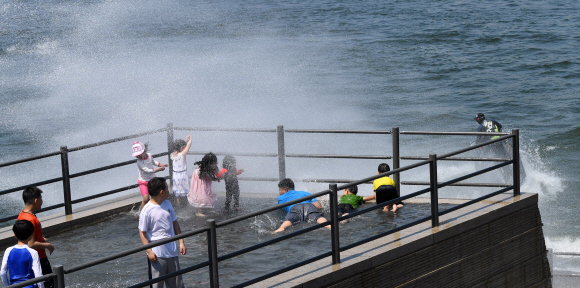 전국적으로 때이른 더위가 기승을 부린 21일 오후 서울 영등포구 여의도 물빛광장을 찾은 어린이들이 제트스키가 일으킨 물보라를 맞고 있다.  손형준 기자 boltagoo@seoul.co.kr