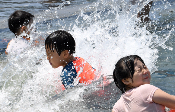 전국적으로 때이른 더위가 기승을 부린 21일 오후 서울 영등포구 여의도 물빛광장을 찾은 어린이들이 물놀이를 즐기며 더위를 식히고 있다.  손형준 기자 boltagoo@seoul.co.kr