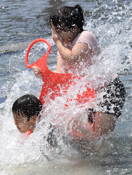 전국적으로 때이른 더위가 기승을 부린 21일 오후 서울 영등포구 여의도 물빛광장에서 어린이들이 물놀이를 하고 있다.  손형준 기자 boltagoo@seoul.co.kr