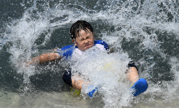 전국적으로 때이른 더위가 기승을 부린 21일 오후 서울 영등포구 여의도 물빛광장을 찾은 한 어린이가 물놀이를 즐기며 더위를 식히고 있다.  손형준 기자 boltagoo@seoul.co.kr