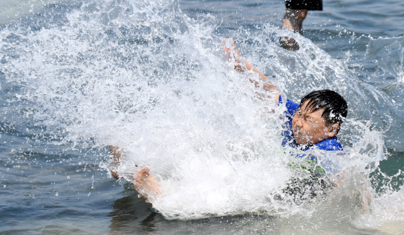 전국적으로 때이른 더위가 기승을 부린 21일 오후 서울 영등포구 여의도 물빛광장을 찾은 한 어린이가 물놀이를 즐기며 더위를 식히고 있다.  손형준 기자 boltagoo@seoul.co.kr