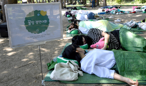 21일 서울 성동구 서울숲 가족마당에서 유한킴벌리가 개최한 ’숲 속 꿀잠경연대회’에서 참가자들이 잠을 청하고 있다.  박지환 기자 popocar@seoul.co.kr