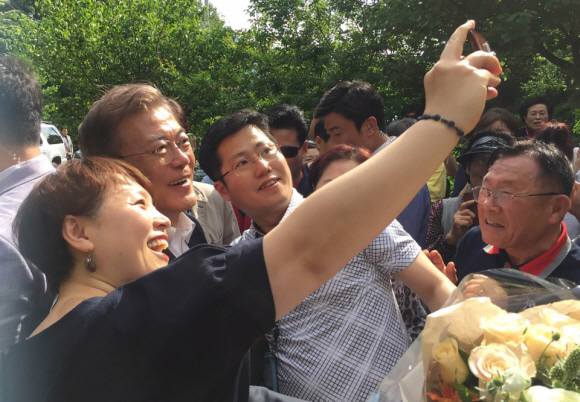 문재인 대통령이 21일 오후 경남 양산시 사저 앞에서 환영나온 지역 주민과 셀카를 찍고 있다. 청와대제공