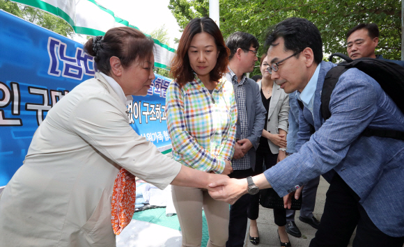 하승창(오른쪽) 청와대 사회혁신수석이 지난 20일 서울 종로구 청운동 주민센터 앞에 있는 스텔라데이지호 사고 실종자 가족들의 농성장을 방문해 이야기를 나누고 있다. 청와대사진기자단