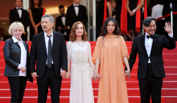 21일(현지시간) 프랑스 칸에서 열린 ‘제70회 칸 영화제’에 (왼쪽부터) 영화감독 클레어 드니와 홍상수, 배우 이자벨 위페르, 김민희, 정진영이 손을 잡고 나란히 입장하고 있다. AFP 연합뉴스