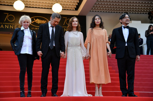 21일(현지시간) 프랑스 칸에서 열린 ‘제70회 칸 영화제’에 (왼쪽부터) 영화감독 클레어 드니와 홍상수, 배우 이자벨 위페르, 김민희, 정진영이 손을 잡고 나란히 입장하고 있다. AFP 연합뉴스