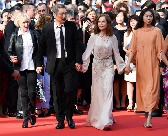 21일(현지시간) 프랑스 칸에서 열린 ‘제70회 칸 영화제’에 (왼쪽부터) 영화감독 클레어 드니와 홍상수, 배우 이자벨 위페르, 김민희가  손을 잡고 나란히 입장하고 있다. AFP 연합뉴스