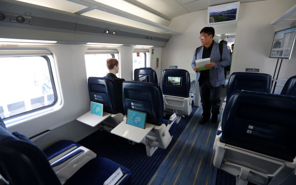 수송력이 대폭 향상된 국내 최초 동력분산식 고속차량의 실물모형 전시 및 품평회가 24일 오전 서울 용산역 광장에서 열렸다. 코레일은  동력분산식 고속차량은 앞뒤로 별도의 기관차가 필요했던 기존 고속열차와는 달리 전 차량을 객실로 이용할 수 있어 기존 KTX-산천 대비 1량당 좌석수가 평균 75%향상됐다고 밝혔다. 품평회에 참가한 시민들이 고속열차 모형에 올라 의자 등 내부 디자인을 살펴보고 있다.   연합뉴스