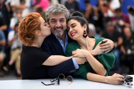 23일(현지시간) 프랑스 칸에서 열린 ‘제70회 칸 영화제’에 아르헨티나 영화배우 리카도 다린(가운데)이 영화 ‘La Cordillera - El Presidente’에 함께 출연한 두 여배우 돌로레스 폰지(왼쪽)와 에리카 리바스의 키스를 받으며 행복한 표정을 짓고 있다.<br>AFP 연합뉴스