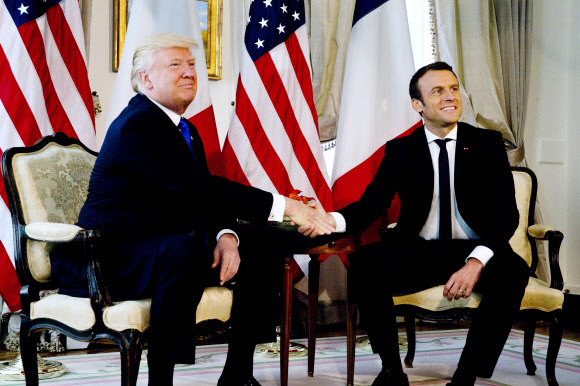 25일(현지시간) 벨기에서 에마뉘엘 마크롱 프랑스 대통령과 악수를 한 도널드 트럼프 미국 대통령이 먼저 손을 풀고 있다. EPA 연합뉴스