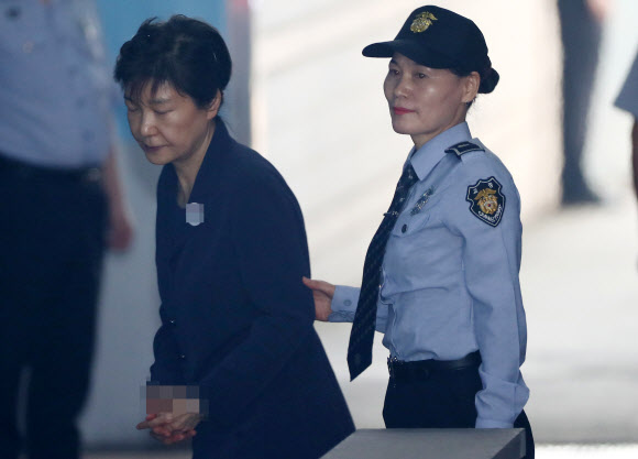 ’비선 실세’ 최순실씨와 공모해 592억원대 뇌물을 받거나 요구·약속한 혐의로 구속기소 된 박근혜 전 대통령이 29일 오전 호송차에서 내려 속행공판이 열리는 서울중앙지법 법정으로 향하고 있다.  연합뉴스
