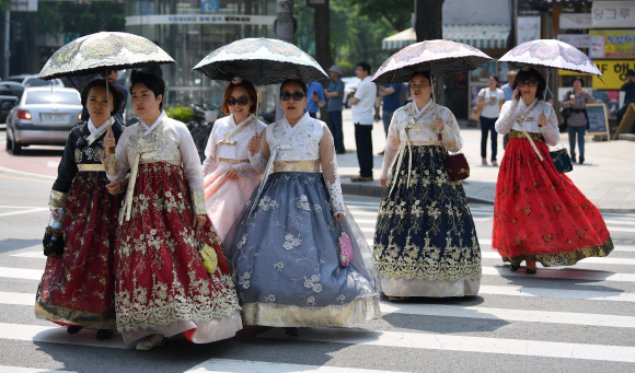 자외선 주의보가 내려진 29일 서울 광화문을 찾은 시민들이 한복을 입은채 우산을 들고 거리를 걷고 있다. <br>박지환 기자 popocar@seoul.co.kr