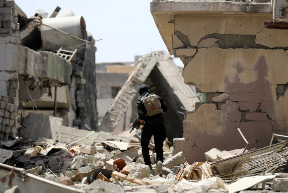 이라크군 병사가 28일(현지시간) 이슬람국가(IS) 최대 근거지이자 최후 저지선인 모술 서부의 알사하 지역에서 조심스럽게 전진하고 있다. 모술 AFP 연합뉴스