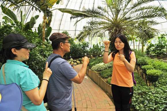 청각장애인들이 동행한 수화 통역사(오른쪽)의 관광지 설명을 듣고 있다.