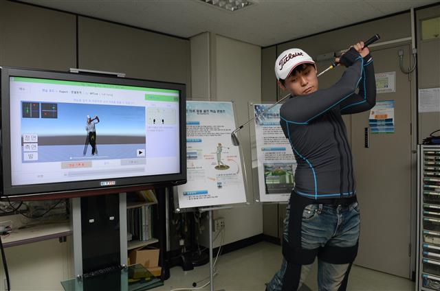 자세교정 스마트웨어를 입고 3차원(3D) 입체 동작 학습프로그램을 통해 골프 스윙 동작 교정을 받고 있는 모습. ETRI 제공