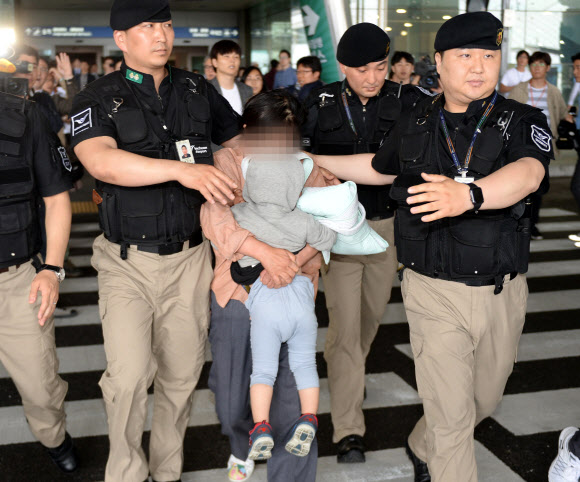 정유라 씨 아들과 보모가 7일 오후 인천국제공항으로 입국, 보호를 받으며 공항을 빠져나가고 있다. 연합뉴스
