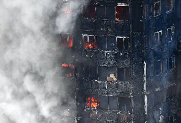 14일(현지시간) 영국 런던 서부 래티머 로드의 24층 아파트 ‘그렌펠 타워’에서 화재가 발생해 건물 전체가 검게 그을리면서 연기가 치솟고 있다. 런던 소방당국은 소방차 40대와 소방관 200명을 출동시켜 화재 진압에 나섰다.  런던 EPA 연합뉴스