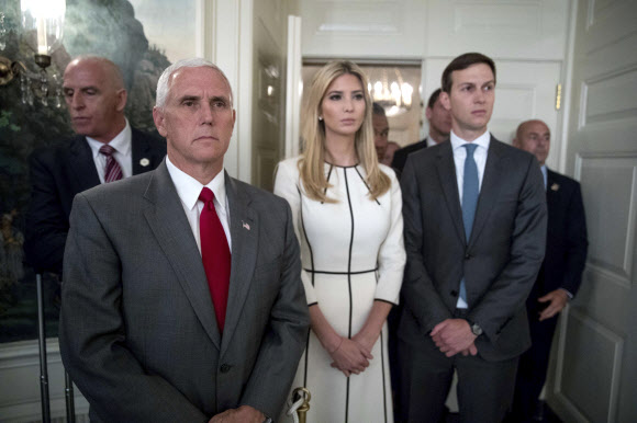14일(현지시간) 도널드 트럼프 대통령의 장녀 이방카 트럼프(가운데)가 남편이자 백악관 수석고문인 자레드 쿠시너(오른쪽)와 마이크 펜스(왼쪽) 미국 부통령과 함께 백악관에서 도널드 트럼프 미국 대통령의 연설을 듣고 있다. AP 연합뉴스
